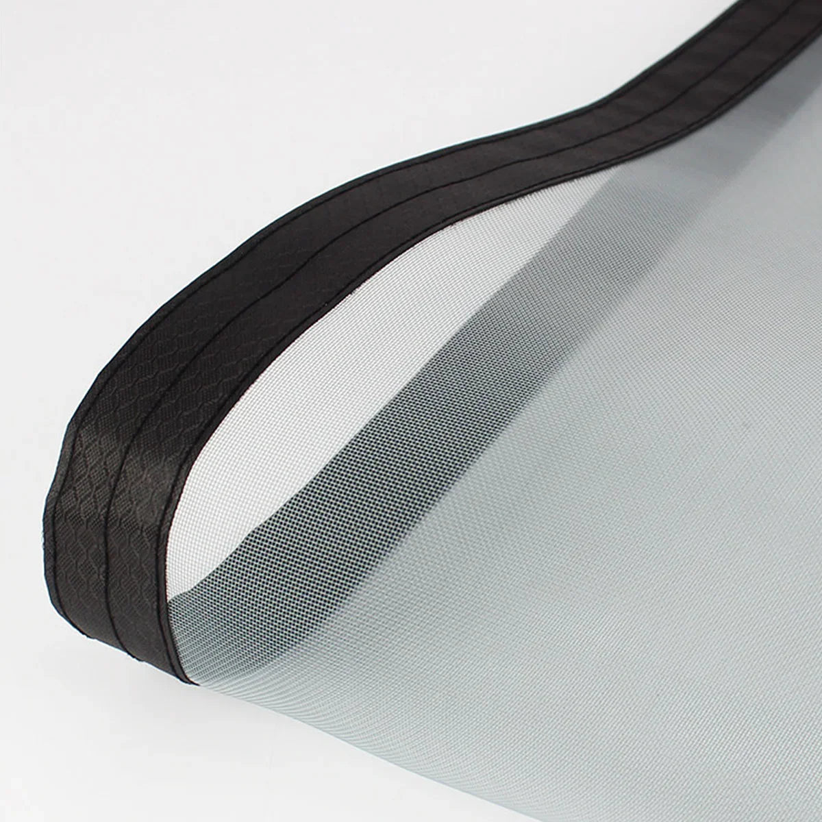 close-up of a fine mesh screen door material with a black reinforced edge