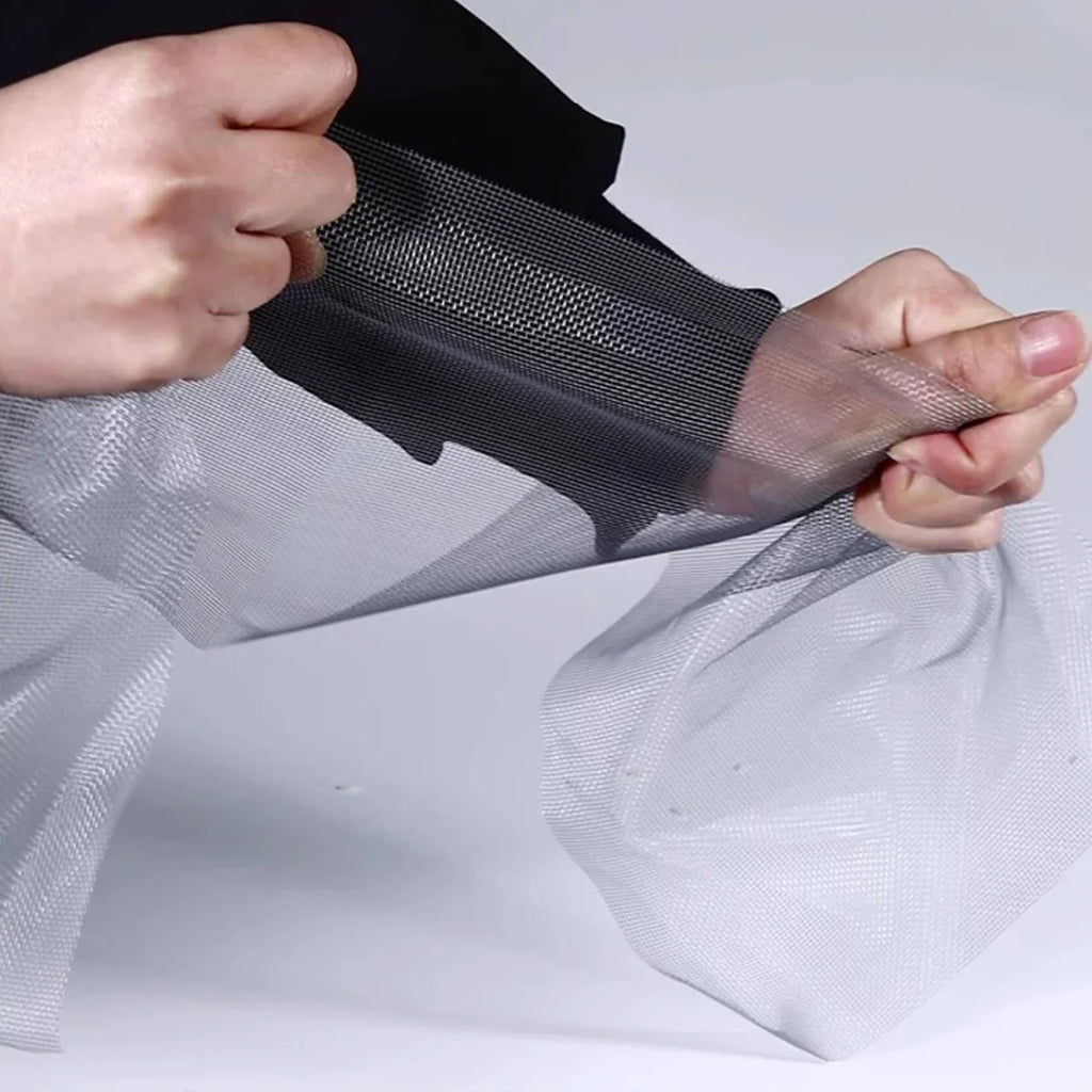 Hands stretching a durable metal mesh window screen material